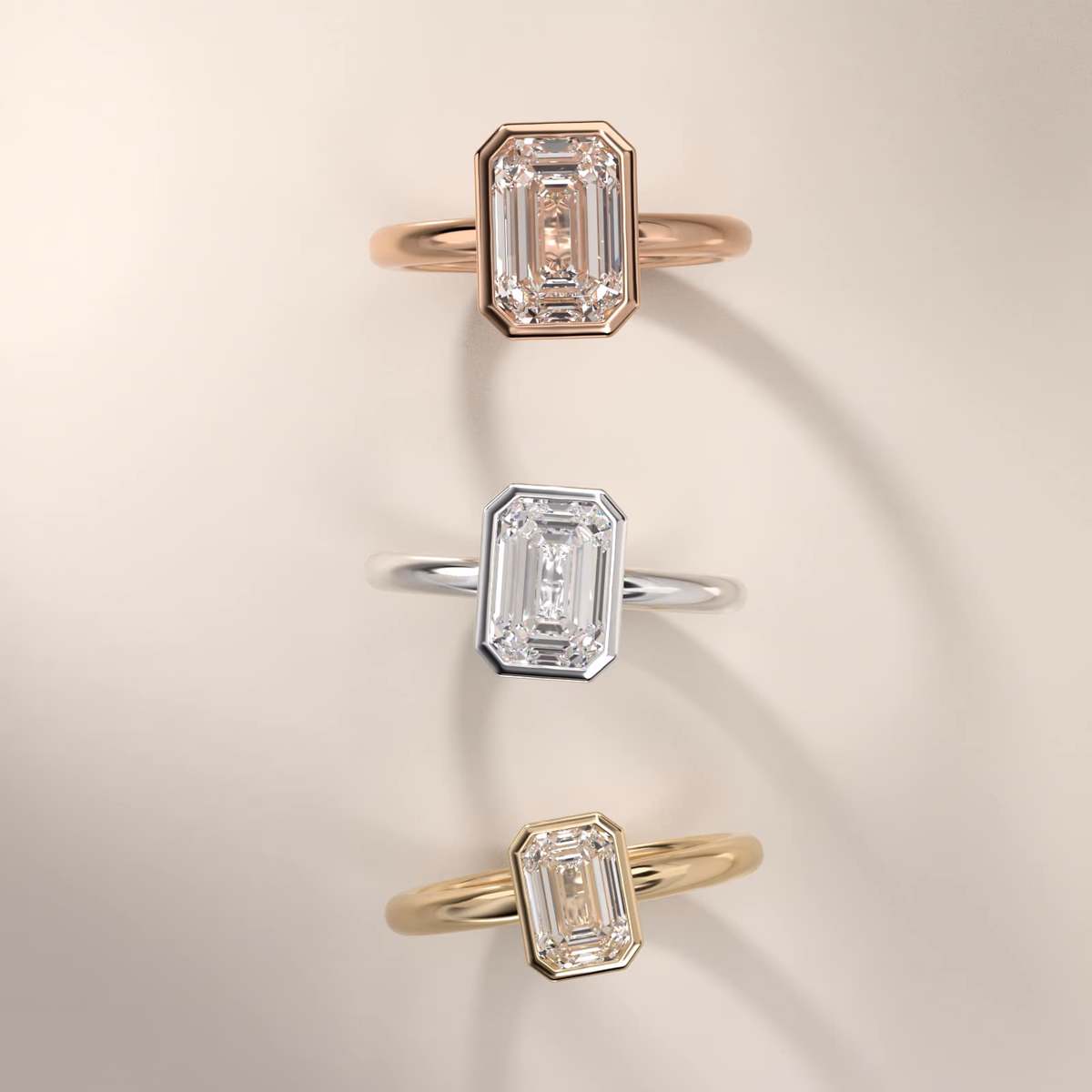 Bezel set emerald cut diamond ring in 14K rose gold, the warm metal framing the rectangular step-cut stone in a full bezel collar
