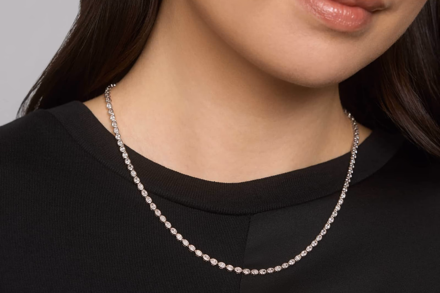 Blue Nile East-West Oval Bezel Diamond Tennis Necklace in 14K White Gold — oval cut diamonds in east-west bezel settings on black backdrop, 7ctw $15,800
