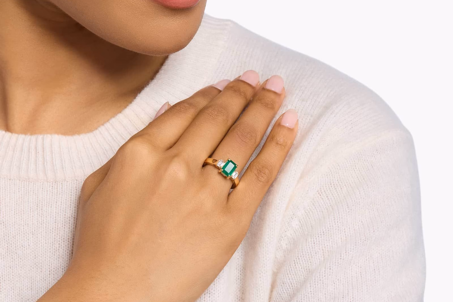 Oval emerald and diamond halo twist ring in yellow gold