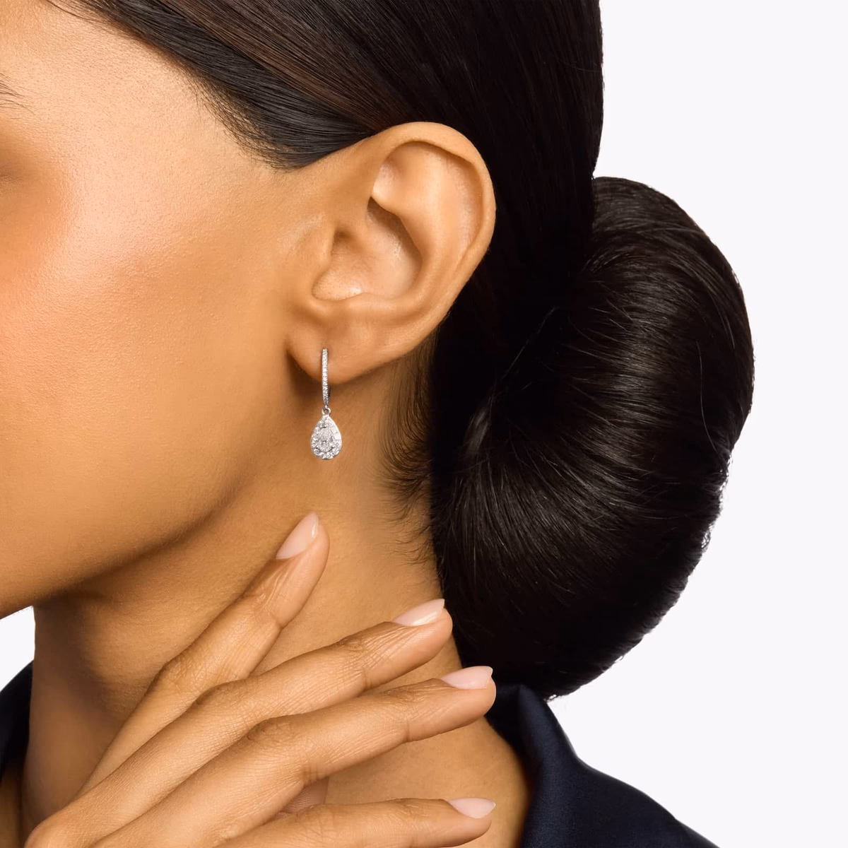Pear shaped lab grown diamond earrings lifestyle — stud earrings worn, yellow gold at ear