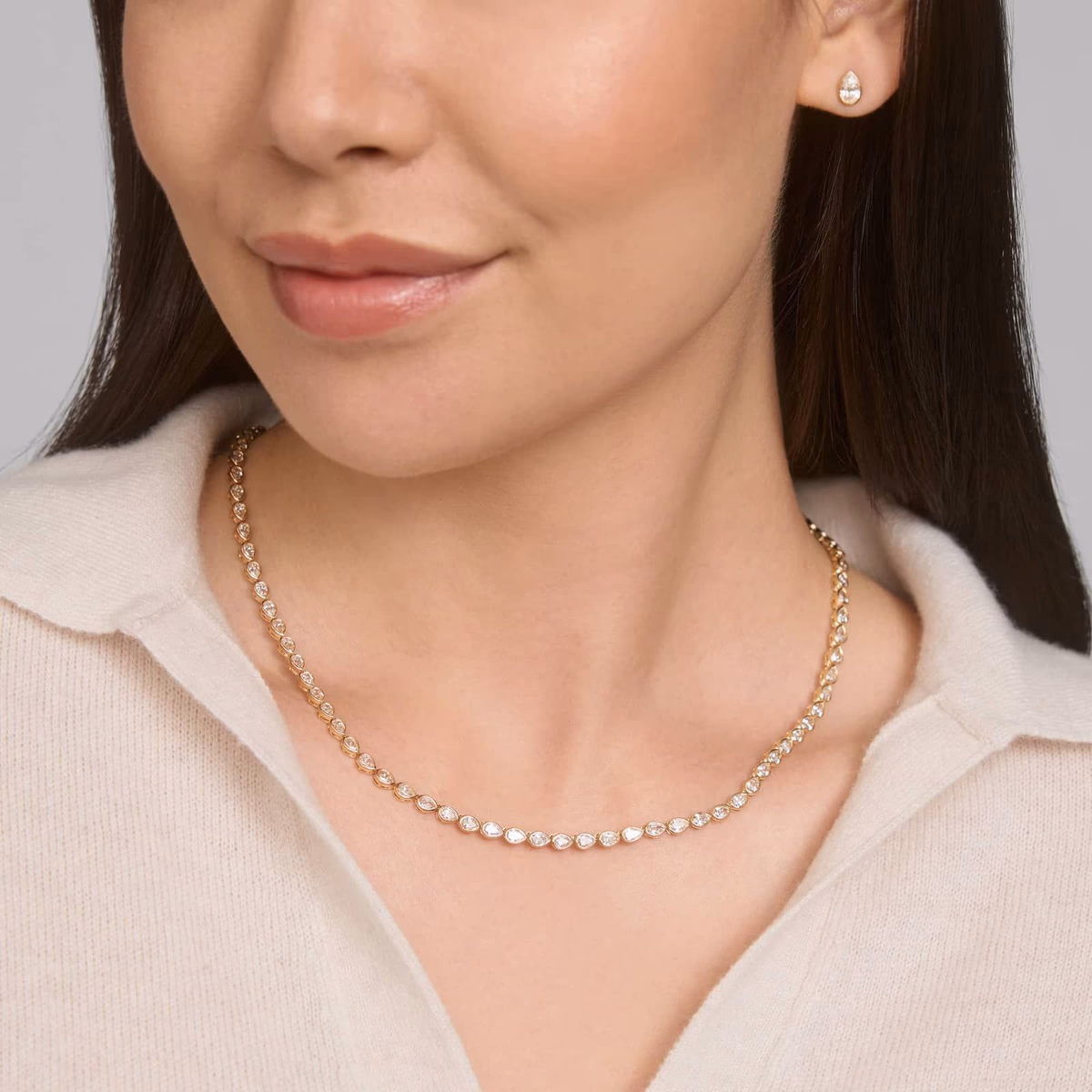 Pear diamond necklace lifestyle — yellow gold pendant worn at décolletage