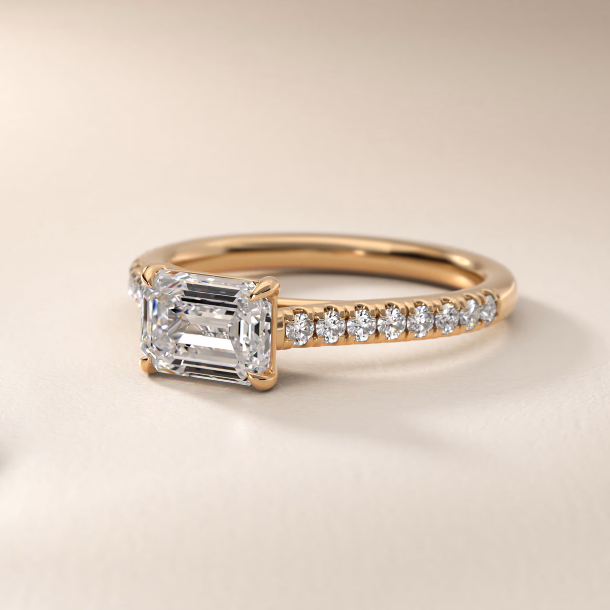 East west emerald cut diamond ring pavé setting yellow gold