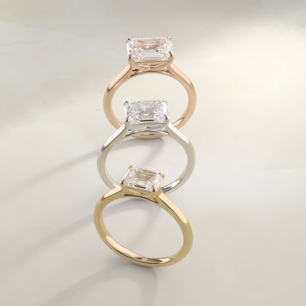 East west emerald cut diamond ring in yellow gold solitaire setting