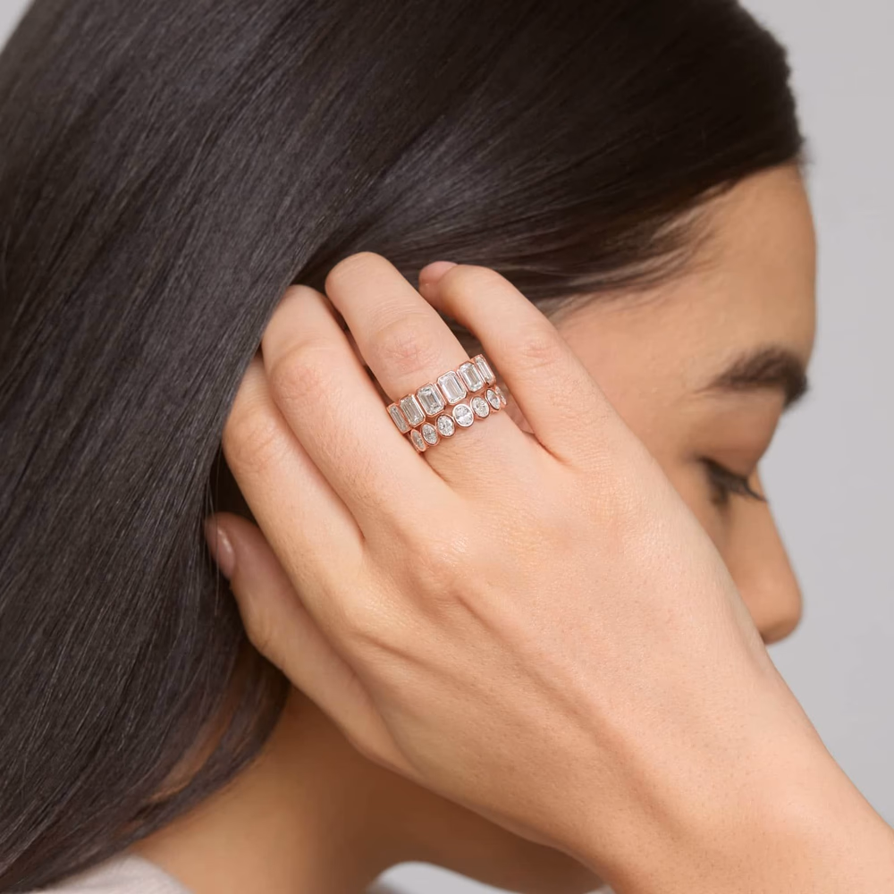Oval diamond wedding band in rose gold — lifestyle photo of the seven-stone bezel lab-grown oval diamond ring in 14K rose gold, showing the warm copper-toned metal complementing the oval stones in a contemporary stacking band design