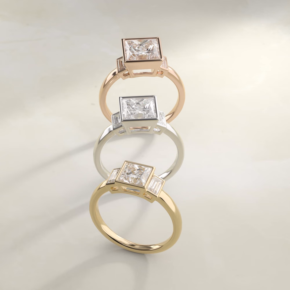 Bezel Straight Baguette Three Stone in 14K Rose Gold — princess cut center with bezeled baguette sides in warm rose gold, romantic metal contrast against white diamonds