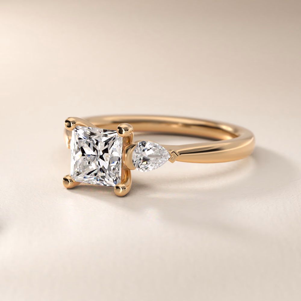 Marquise Cut Diamond Three Stone Engagement Ring in 14K Yellow Gold — princess cut center with marquise side stones oriented horizontally to elongate the design